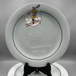 Assiette Longwy à décor de skieur en émaux colorés sur fond céladon