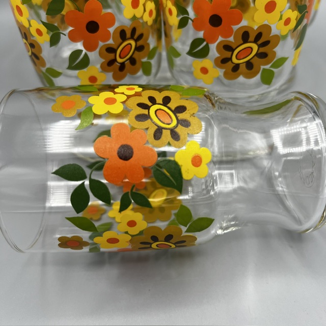 Détail du décor de fleurs orange, jaunes et ocre d’un verre Arcoroc vintage